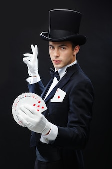 魔法​、​パフォーマンス​、​サーカス​、​ギャンブル​、​カジノ​、​ポーカー​、​ショー​の​コンセプト​-​トランプ​で​トリック​を​示す​シルクハット​の​マジシャン
