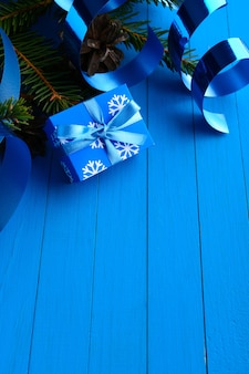 리본과 소나무 나뭇 가지가있는 파란색 선물 상자의 마법 배열