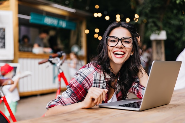 Magnificent caucasian woman in casual outfit posing with laptop. Debonair latin female student laughing.