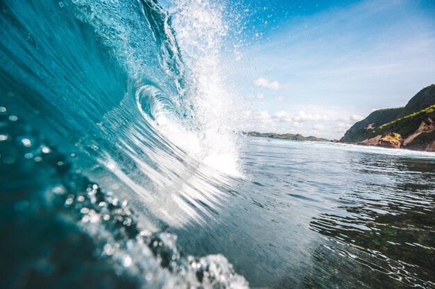 Великолепный вид на волну с камнями на заднем плане, сделанный на острове Ломбок, Индонезия.