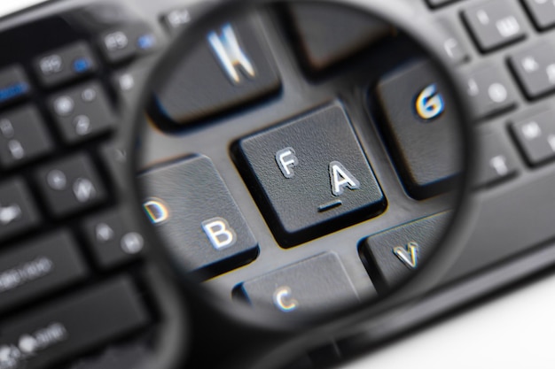 Magnifying glass on black keyboard