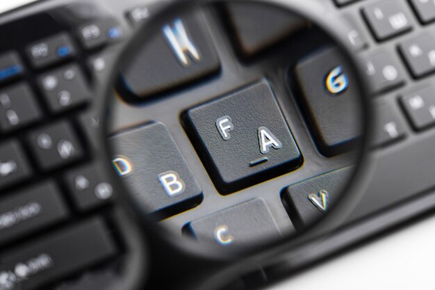 Magnifying glass on black keyboard