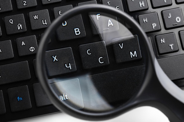 magnifying glass on black keyboard