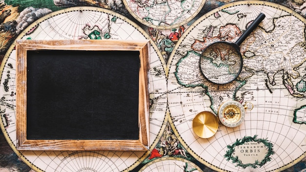 Magnifying glass and compass near empty blackboard