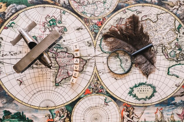 Magnifying glass and feathers near travel writing and plane