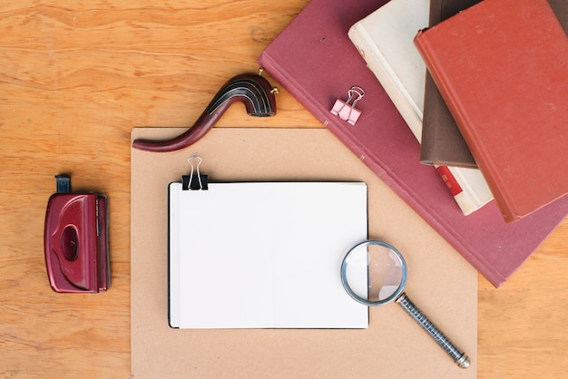 Magnifying glass and pipe near notepads