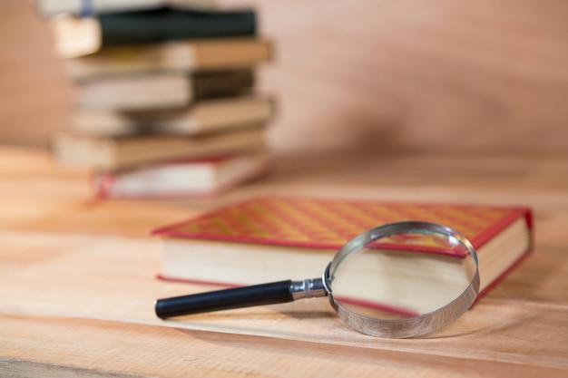 Magnifying glass with a book on a table