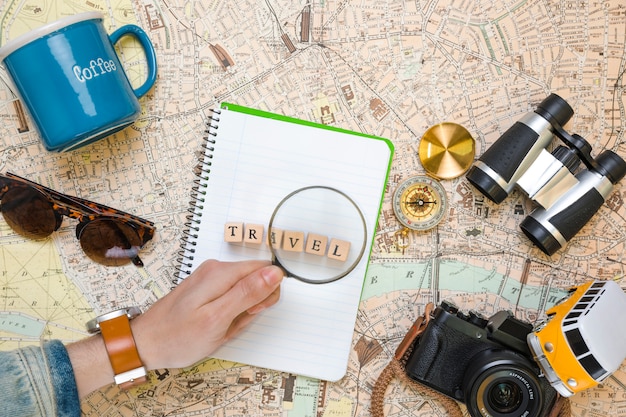 Magnifying glass on wooden cubes next to travel elements