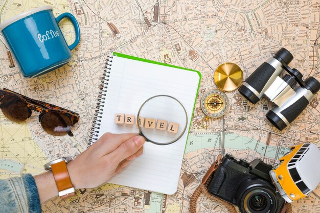 Magnifying glass on wooden cubes next to travel elements