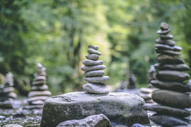 Foto gratuita maestoso scatto di molte piramidi di pietra in equilibrio sull'acqua di un fiume