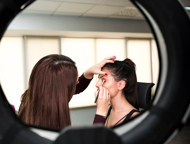 Free photo make up artist applying make up