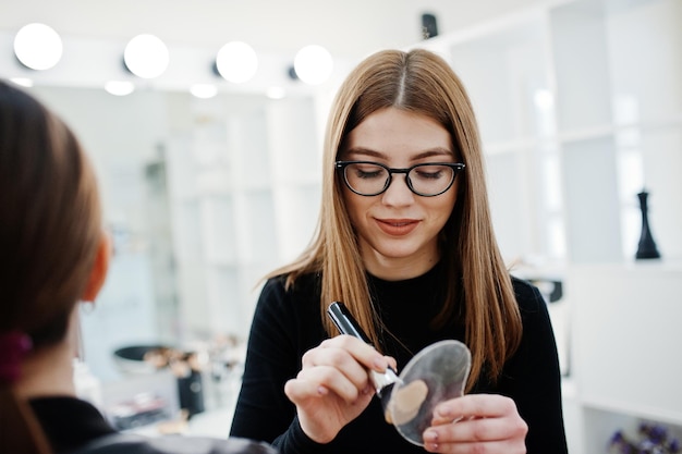 Free photo make up artist work in her beauty visage studio salon woman applying by professional make up master beauty club concept