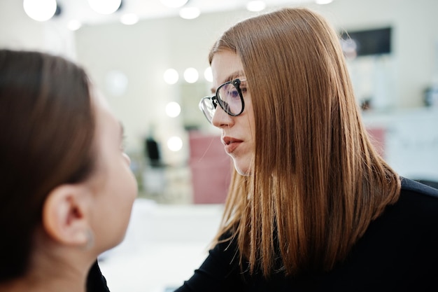 Make up artist work in her beauty visage studio salon Woman applying by professional make up master Beauty club concept