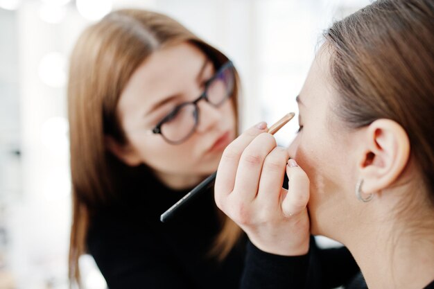 Make up artist work in her beauty visage studio salon Woman applying by professional make up master Beauty club concept