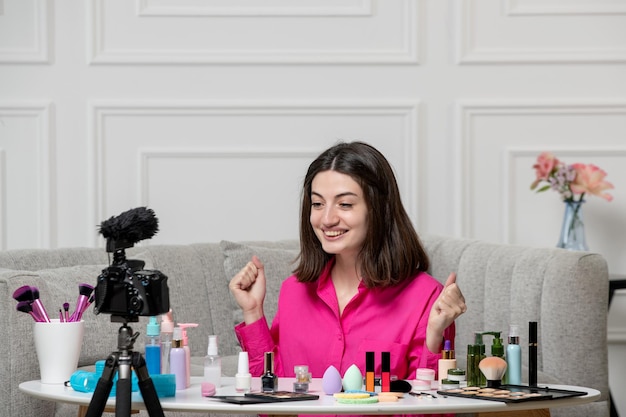 Make up blogger lovely cute brunette young girl recording blog on camera very happy
