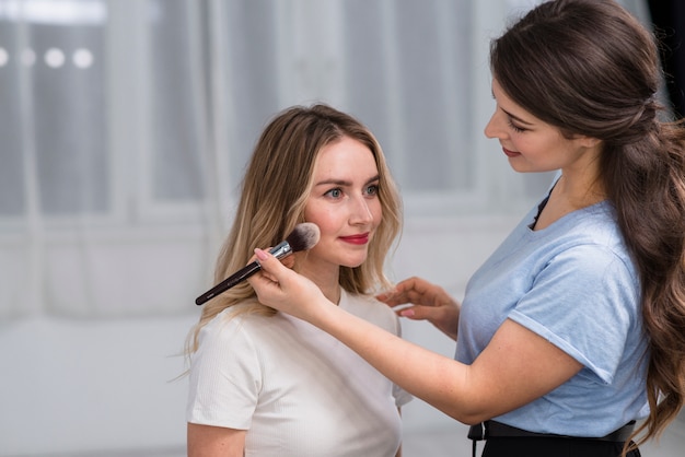 Makeup artist preparing woman 