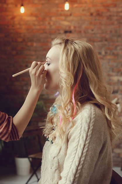 Makeup artist with beautiful blond woman