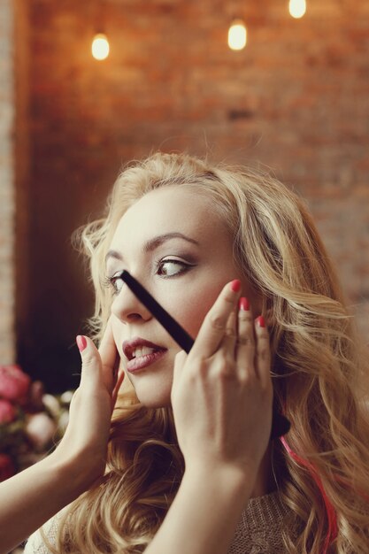 Makeup artist with beautiful blond woman