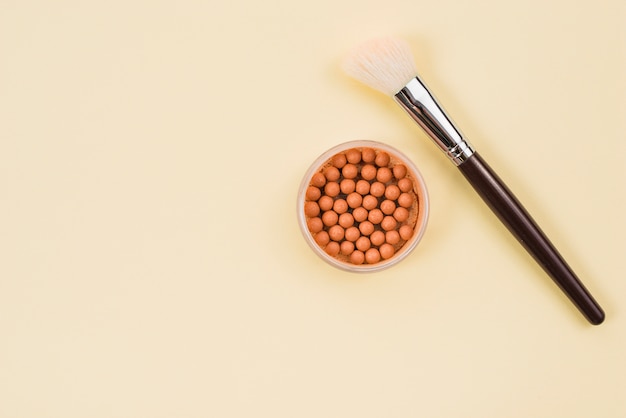 Makeup brush and blush on light background