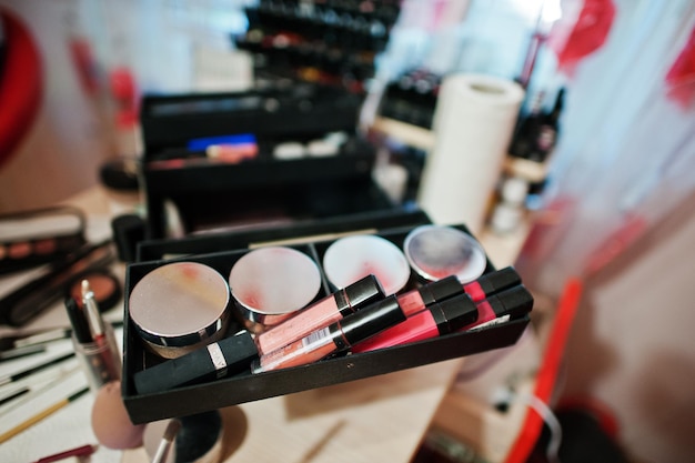 Makeup brush and cosmetics palette at table