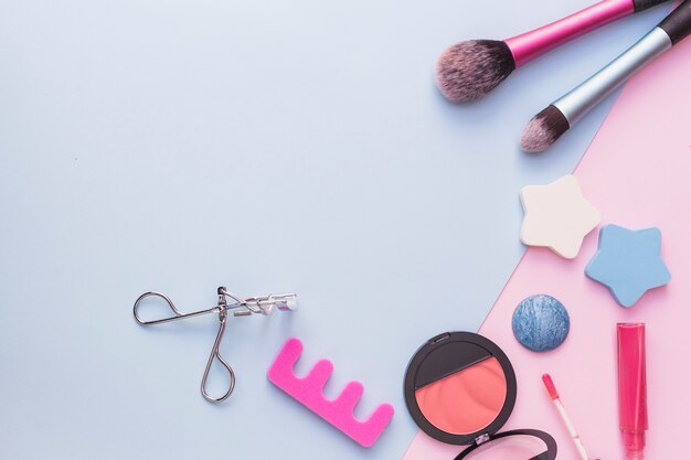 Makeup brush; star sponge; pink blusher; eyelash curler and lipstick on dual backdrop