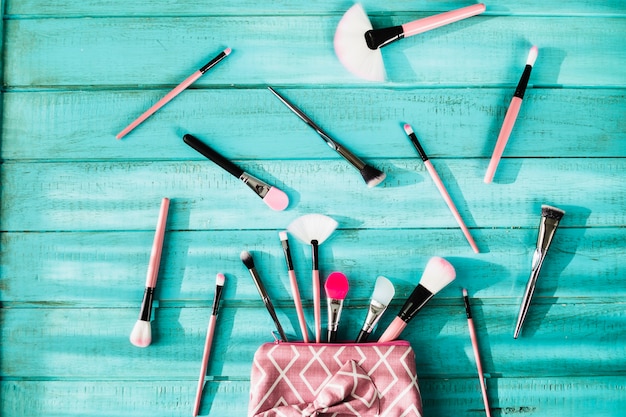 Foto gratuita spazzole di trucco vicino alla borsa dei cosmetici