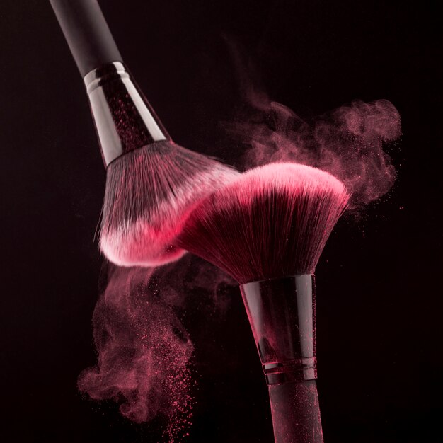 渦巻くピンクの粉と化粧筆
