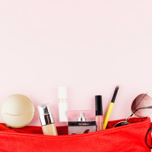 Makeup products lying in red bag
