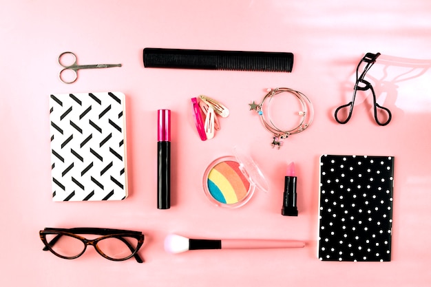 Makeup supplies near notebooks and glasses