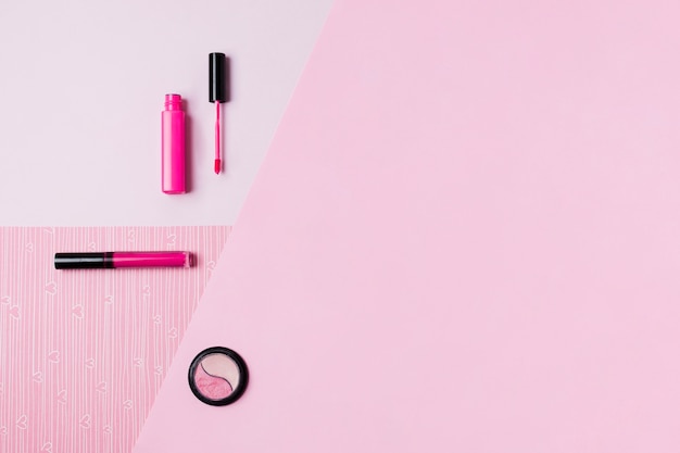 Foto gratuita strumenti di trucco sulla superficie rosa