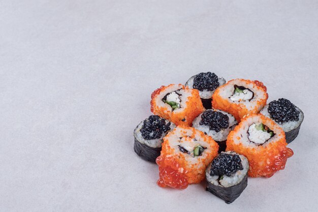 Maki and California sushi rolls on white background.