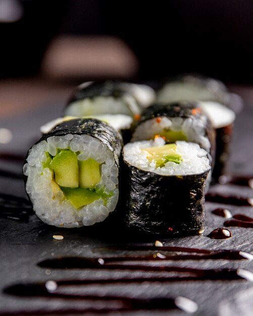 Maki roll with avocado served with sauce