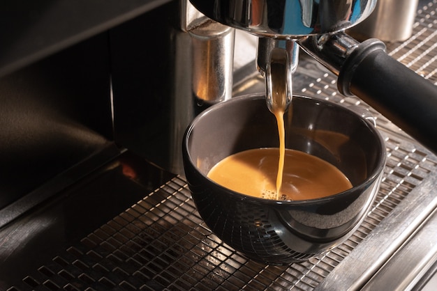 Making fresh espresso in coffee maker. coffee machine makes coffee
