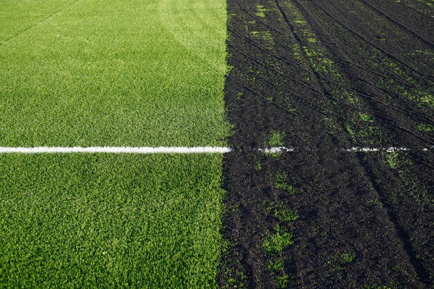 Making off an artificial grass soccer field with green synthetic grass surface and rubber granules