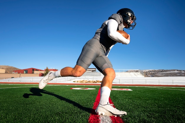 Giocatore di football americano maschio in uniforme sul campo