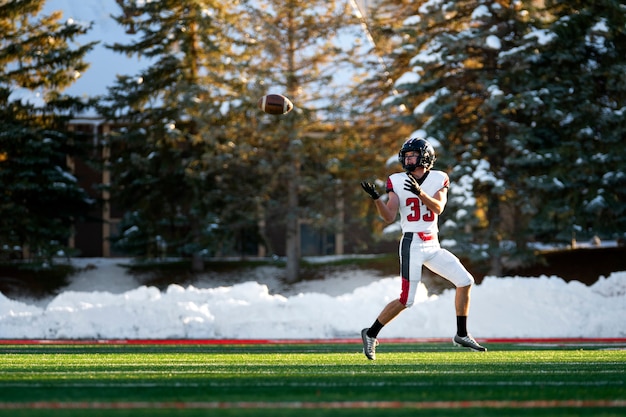 Foto gratuita giocatore di football americano maschio in uniforme sul campo