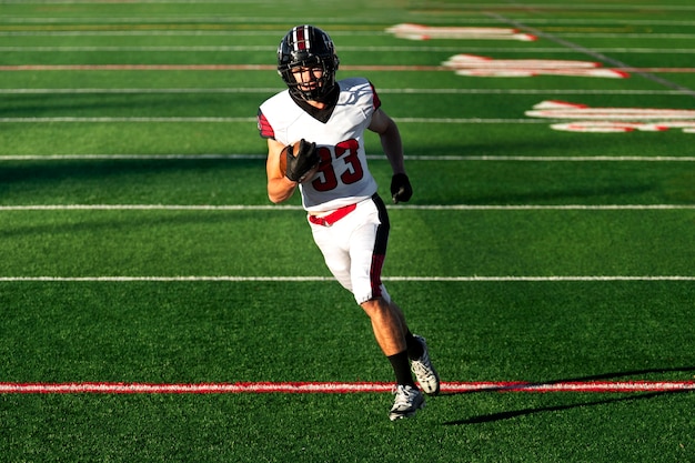 Foto gratuita giocatore di football americano maschio in uniforme sul campo