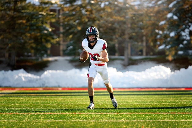 Foto gratuita giocatore di football americano maschio in formazione uniforme sul campo