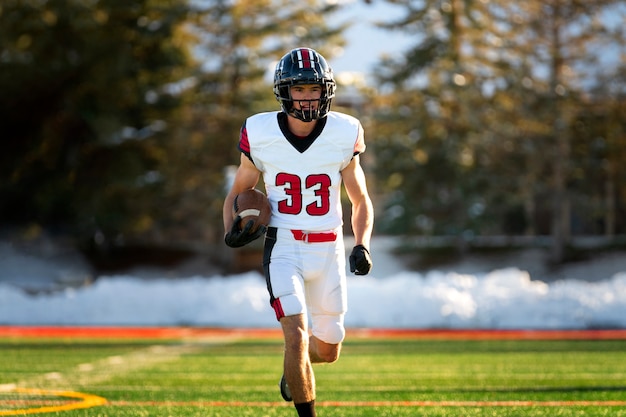 Foto gratuita giocatore di football americano maschio in formazione uniforme sul campo