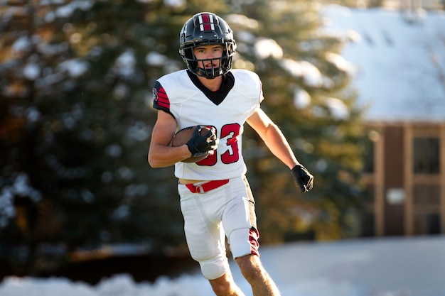 Male american football player in uniform training on the field