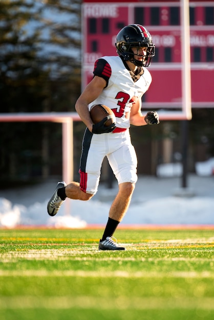 Foto gratuita giocatore di football americano maschio in formazione uniforme sul campo