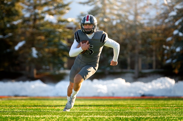 Foto gratuita giocatore di football americano maschio in formazione uniforme sul campo