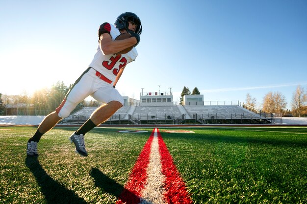 Male american football player in uniform training on the field