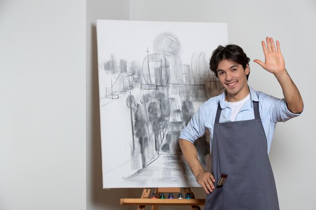 男性アーティストは、スタジオの白い背景の描画アートの中で彼の絵で喜んでポーズをとる