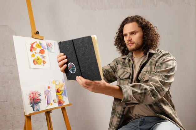 Male artist painting at studio with watercolors