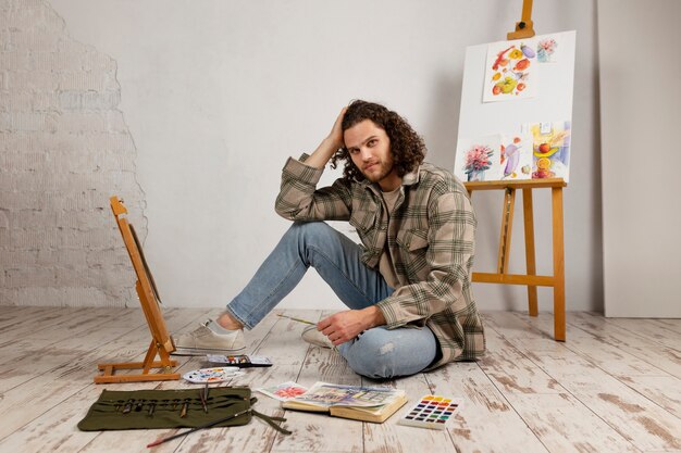水彩絵の具でスタジオで絵を描く男性アーティスト