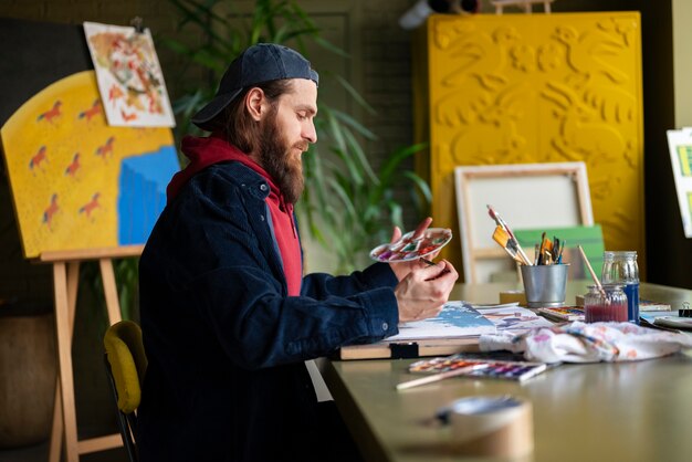 male artist painting with watercolor in the studio