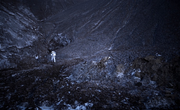 Male astronaut exploring at night during a space mission on an unknown planet