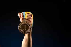 Бесплатное фото Спортсмен-мужчина держит медаль