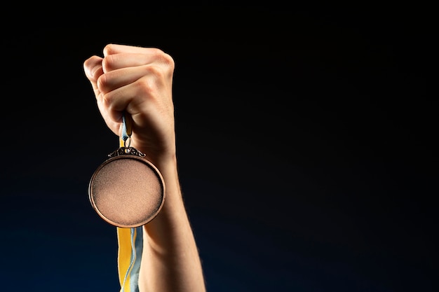 Free photo male athlete holding a gold medal